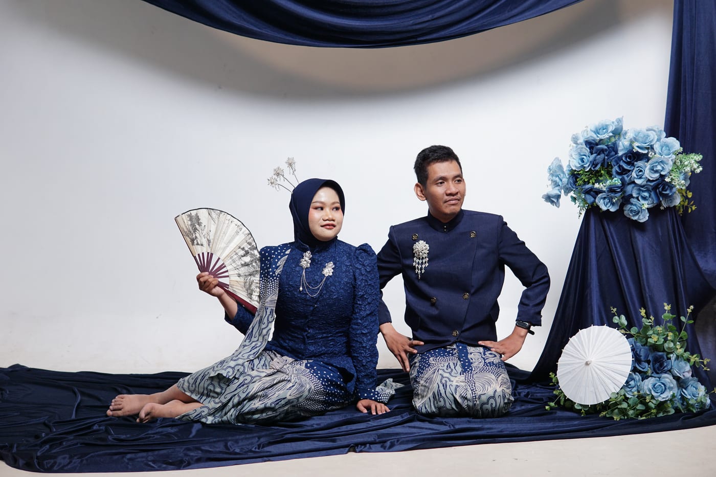 Ula dan Fadli duduk berdampingan dalam busana biru